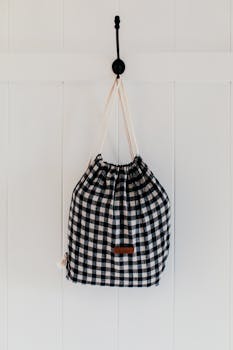 Sustainable checkered cotton bag hanging on wall, perfect for eco-conscious storage solutions.